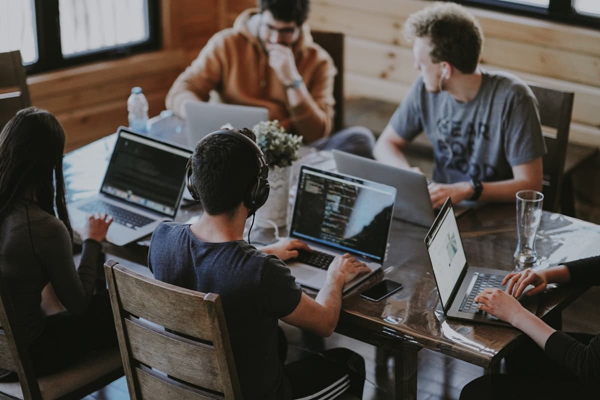 Team members collaborating around a laptop in a meeting